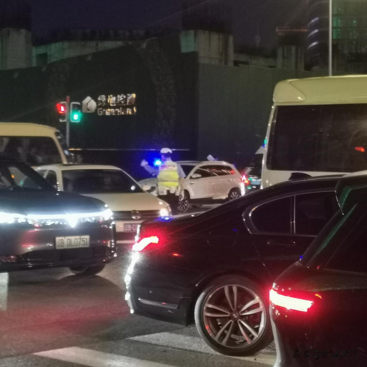两三个交警在十字路口指挥车辆！

这个白色的大客车经过这里，两个交警阻止它通行，