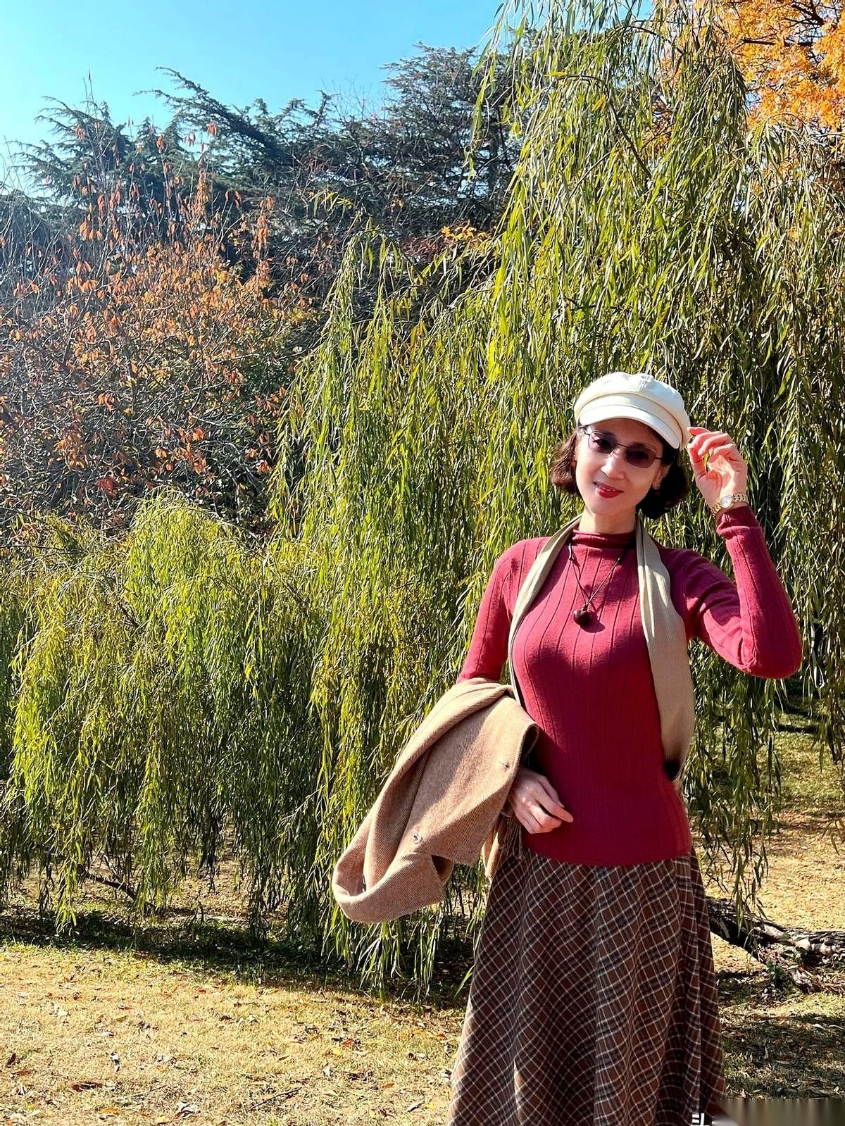 夏天拼了命往上长的柳树，秋天终于怂了。
垂头丧气的，把一头绿发染成了金毛。
风一