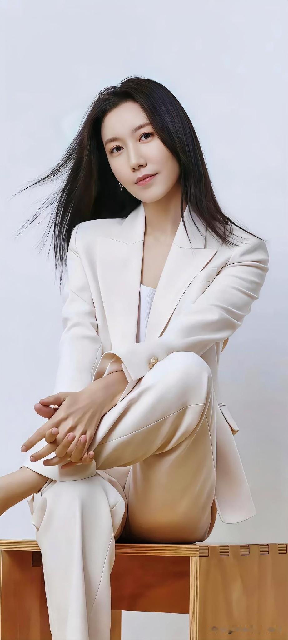 米白西装写意柔美，长发随风轻扬，优雅姿态尽显自信从容。