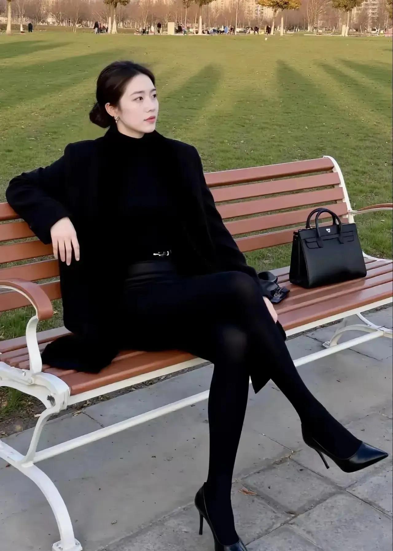 黑色衣服完美地勾勒出她的身形，宛如一朵娇艳的黑玫瑰，绽放着性感与高贵。