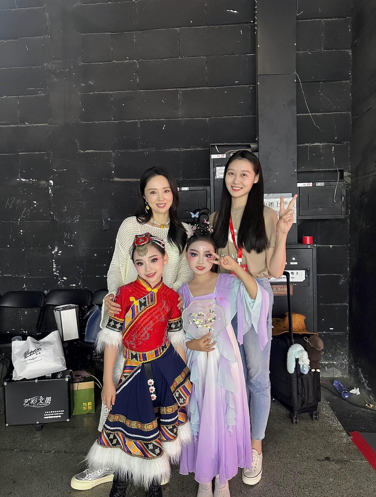近日，董璇的女儿小酒窝与同学一起舞蹈比赛，在后台与舞蹈老师合影的画面。

小酒窝