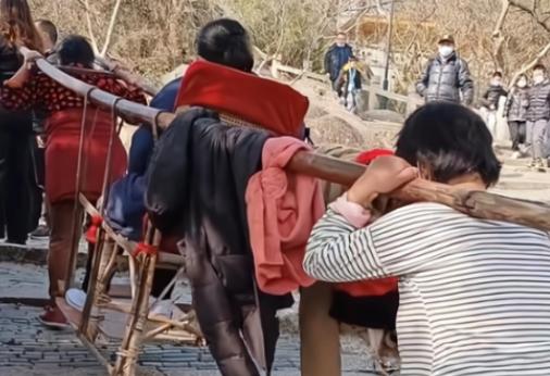 大妈在景区爬山，因为有些累了决定乘坐人工抬轿上山，轿夫表示到山顶是260元，大妈