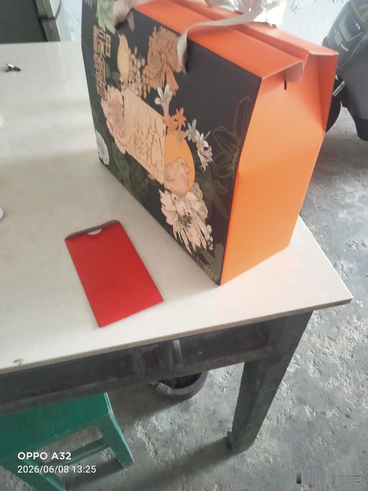 中午我还在热现饭，亲家夫妻俩送来了端午节礼品，一盒粽子和一个红包，亲家母说没买猪