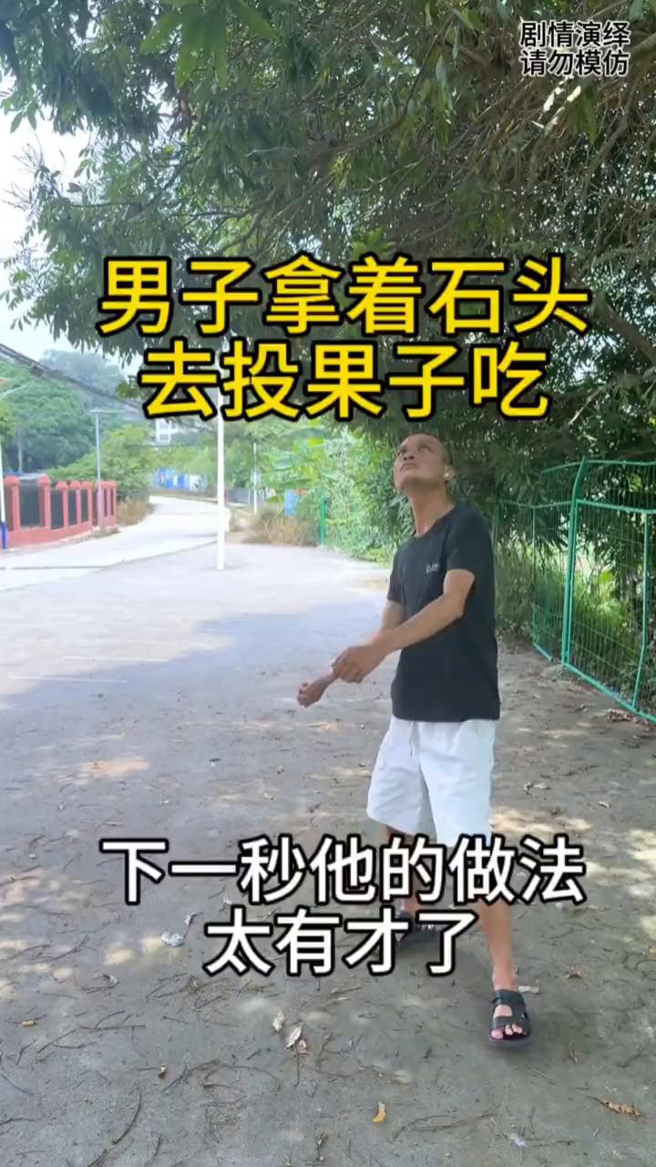 男子拿着石头去投果子吃，下一秒他的做法太有才了。
男子在街上转悠，这时他看到果树