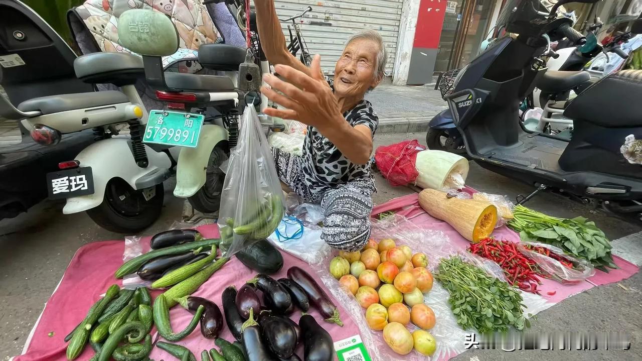 门口的小街上，每天都有附近的农民摆摊卖菜。有个老婆婆经常来。她的菜长得丑，番茄不