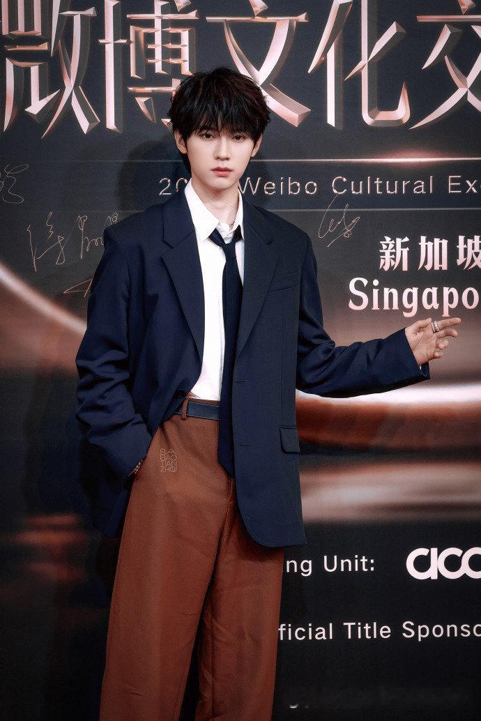 新加坡微博文化交流之夜的红毯上，周翊然的深灰色西装造型太吸睛！修身设计勾勒出流畅