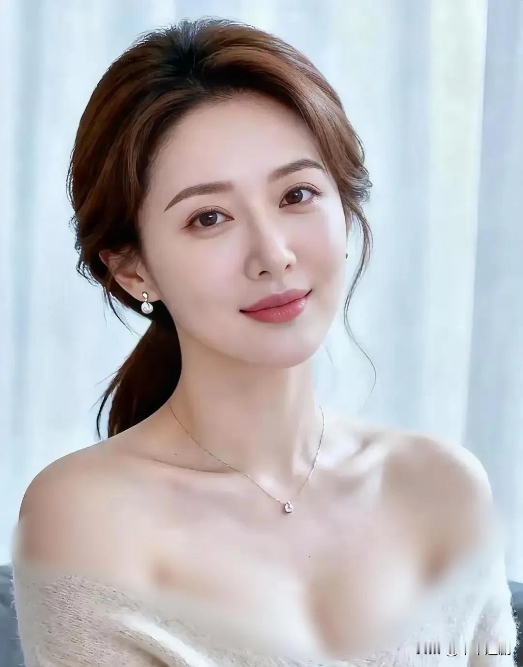 米白针织的露肩设计揉着温柔的慵懒，珍珠耳坠配细钻项链添了精致，柔光里的浅笑，是刻