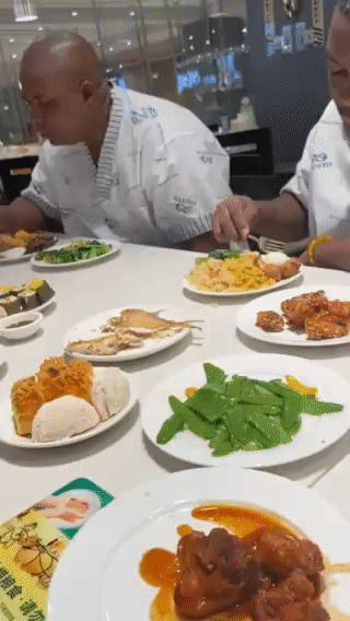 两个非洲黑人在一家餐厅吃自助餐。
由于他们不会用筷子吃饭？
所以刀叉就成了他们最