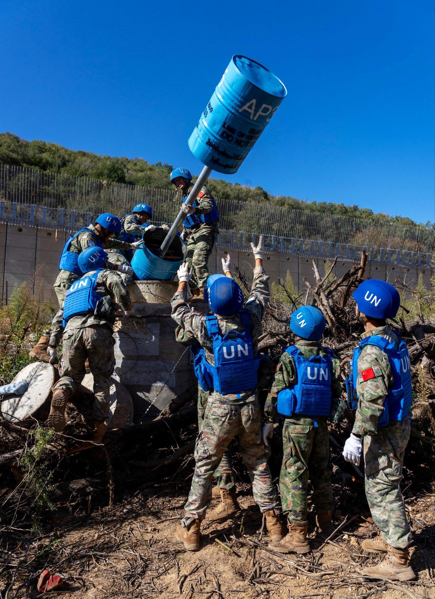 联合驻赴黎巴嫩中国维和部队正在翻新之前受损的标记。维和士兵穿着两种不同颜色的迷彩