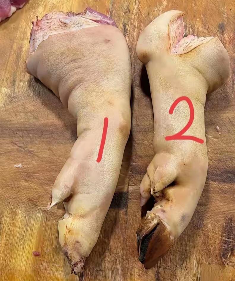 两只猪蹄放在木板上，准备做猪脚饭。谁知道1号和2号有什么区别？25元一个贵吗？怎