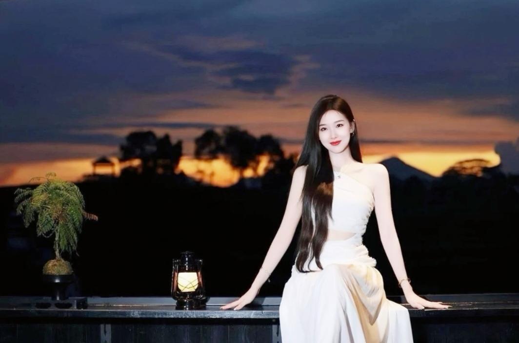 在傍晚的浪漫背景下，少女优雅地倚靠在栏杆上，享受悠静的时光。女孩子怎么穿搭既时尚