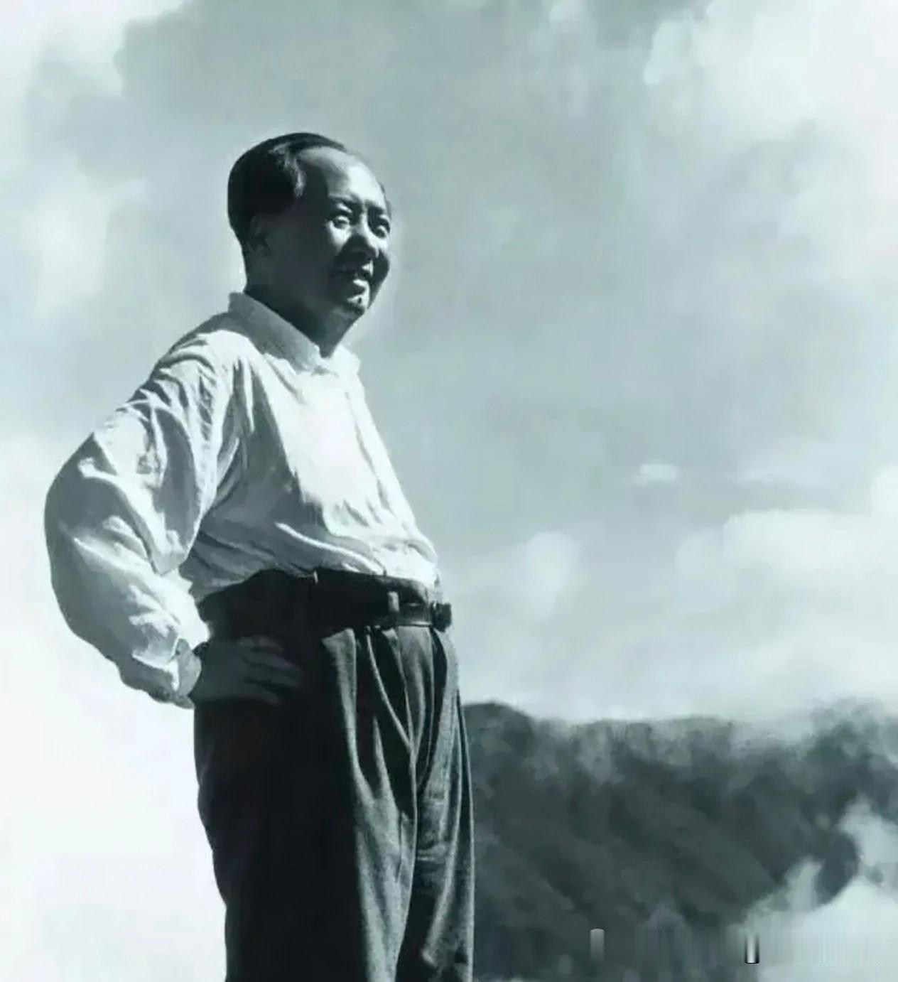 群山云雾间，毛主席单手叉腰挺身而立，身姿舒展挺拔。白衫长裤简约朴素，抬眼望向远方
