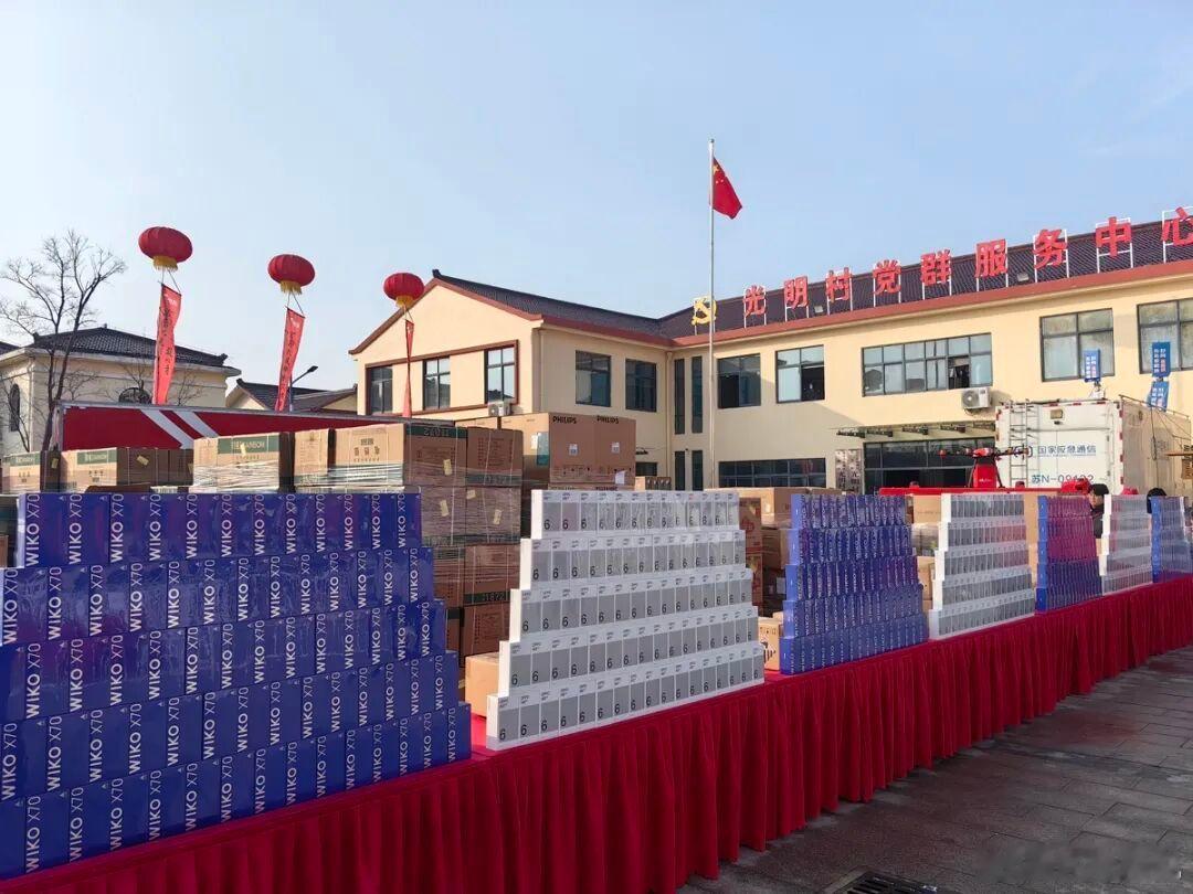 刘强东给家乡送年货现场：上千部AI大屏手机垒成一面墙，村民们骑着空三轮车来排队拖