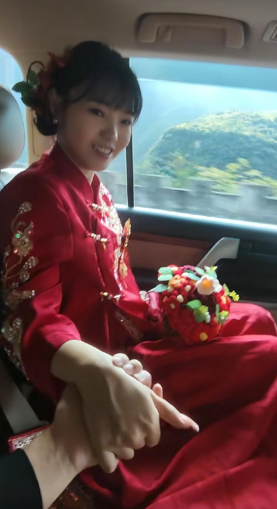 新娘正默默地看着车窗外越来越远的家乡，新郎突然伸过来的一只手，让新娘瞬间幸福地笑