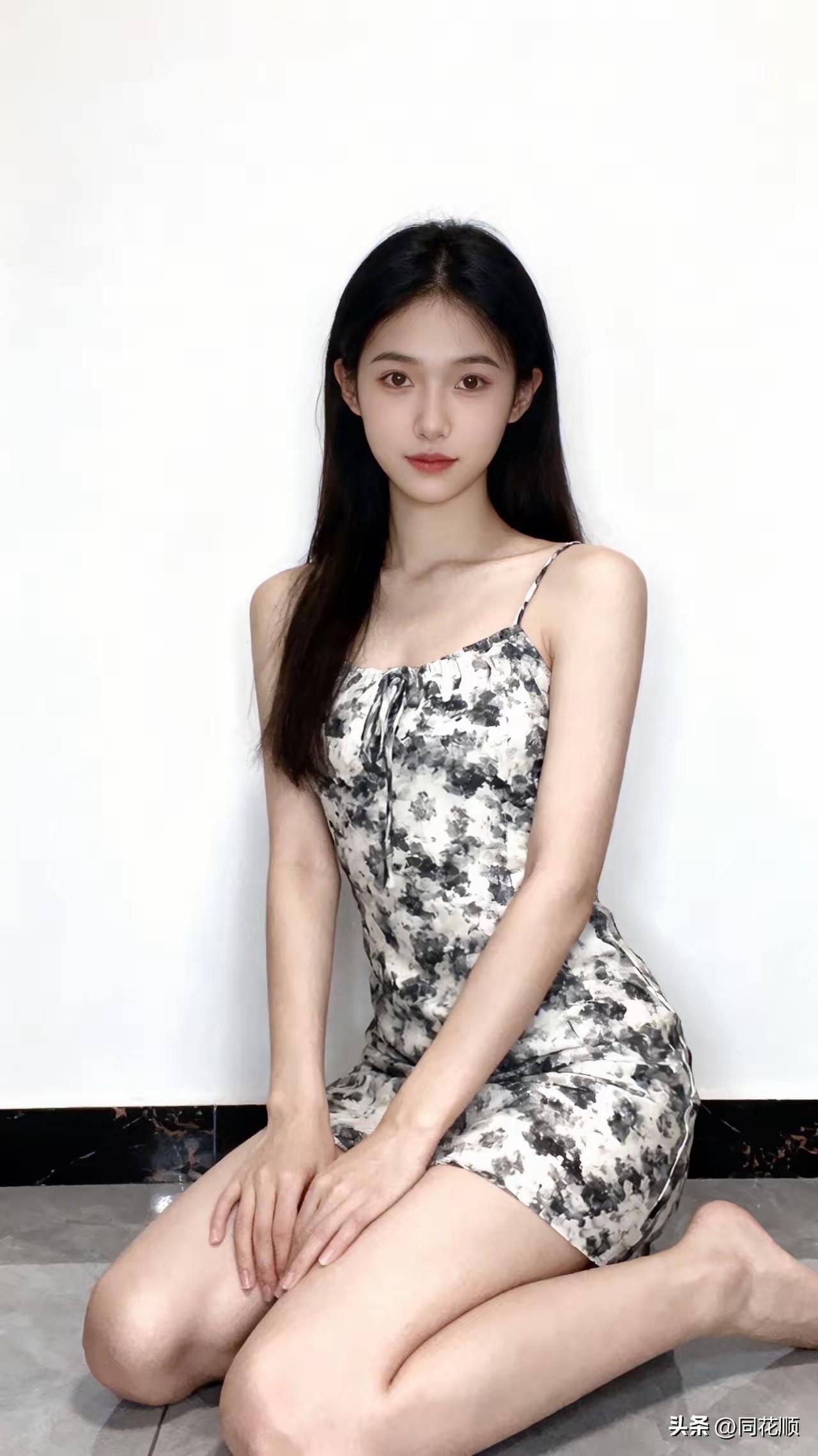 一个女孩穿着花裙坐在地上。