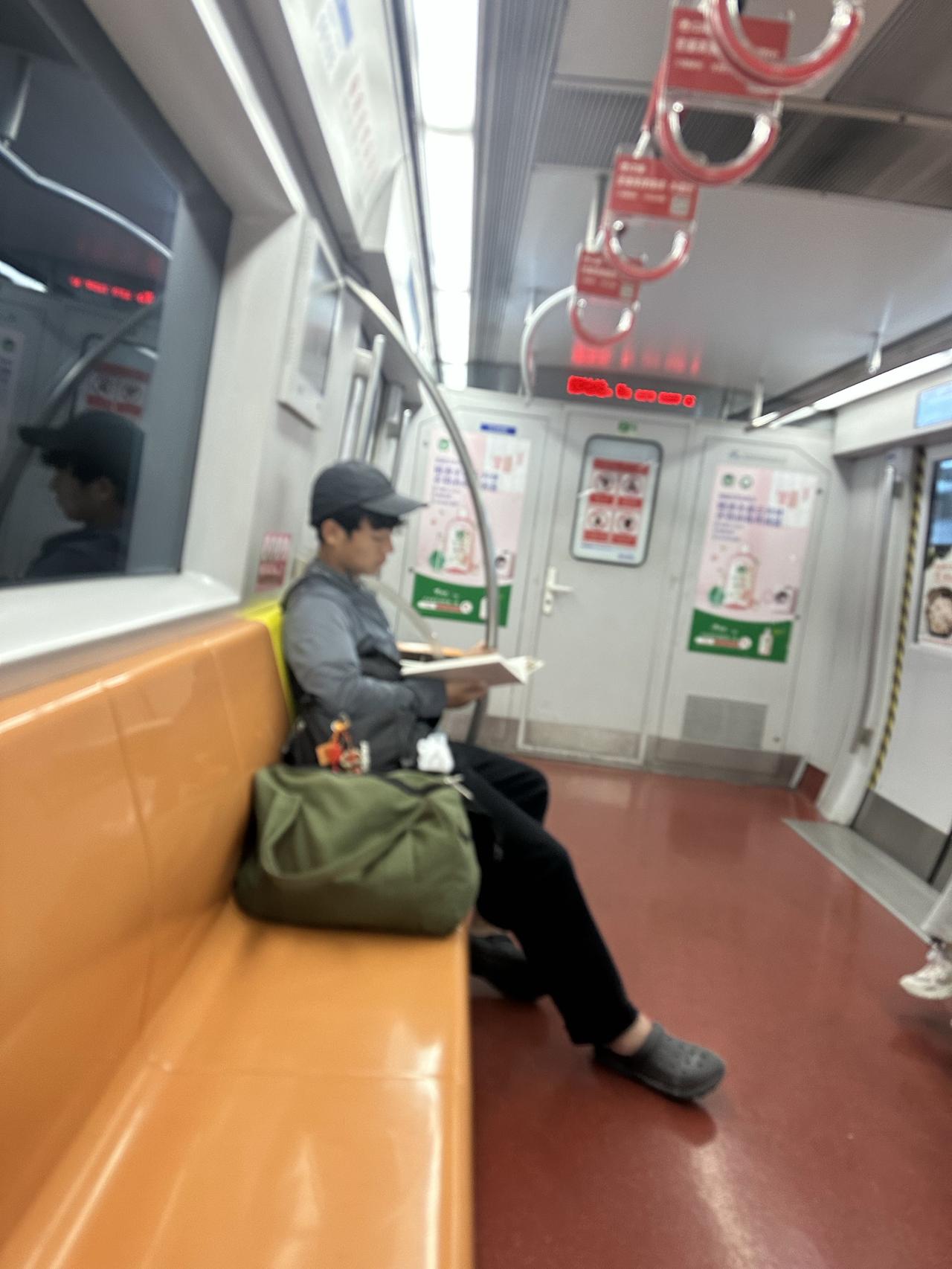地铁一号线，一个年轻小伙子捧着一本书。

曾几何时，车厢是流动的图书馆，如今却成