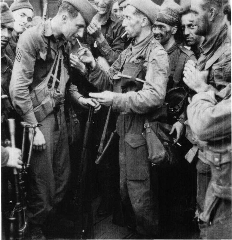 这张照片拍摄的是迪耶普突袭行动归来的英国突击队与美国士兵，他们在纽黑文的码头抽烟