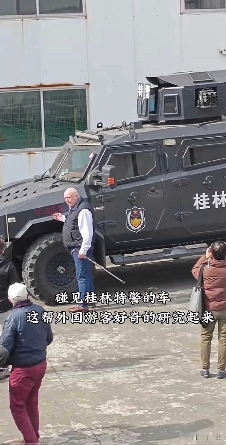 一群老外去桂林旅行，
看完了风景后，
突然发现了一辆特警战车，
于是一群老外就围