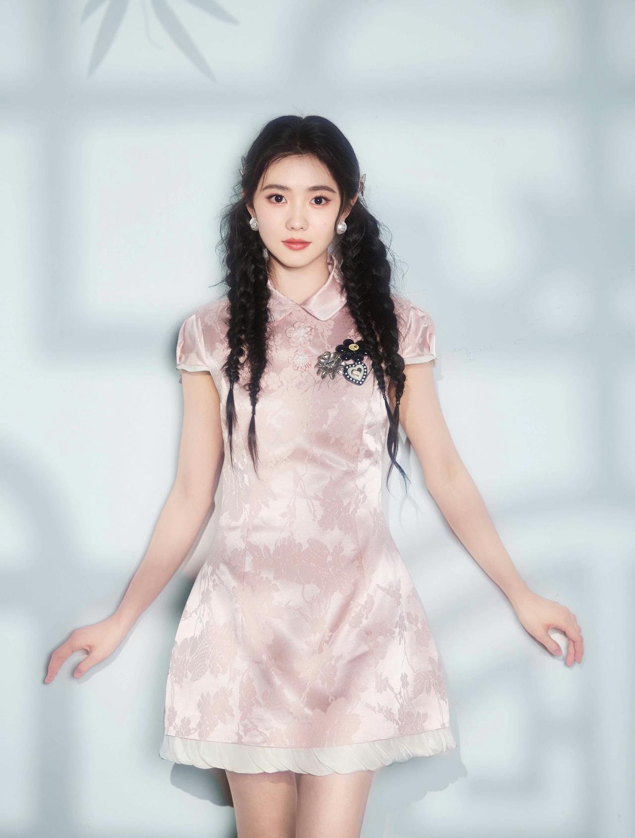 浅粉旗袍织就温柔暗纹，双辫垂落灵动少女气。

竹影光影漫过衣身，新中式的雅致韵味