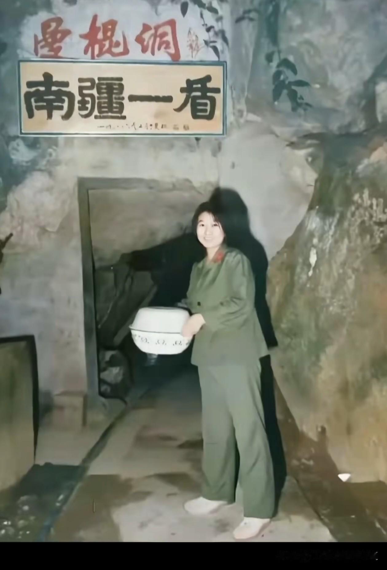 1986年，老山战役的师指挥所“曼棍洞”内，一位女战士身着军装，手捧搪瓷盆，在“