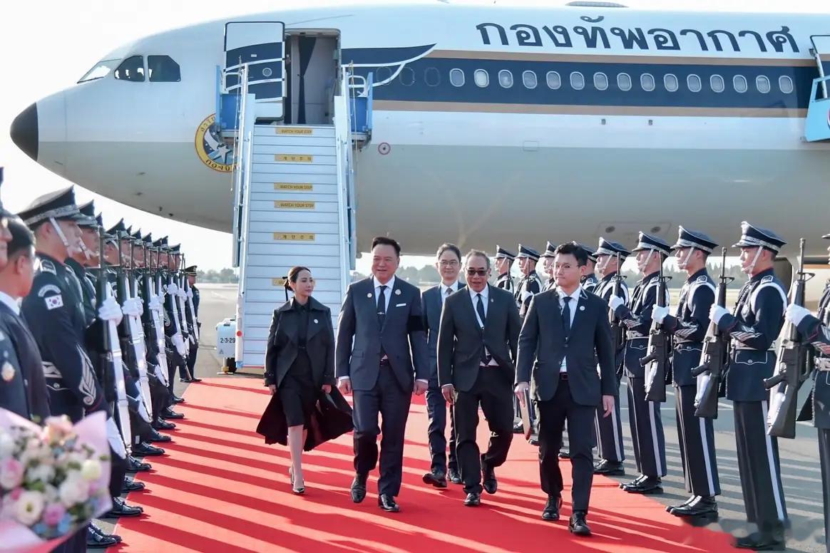 泰国总理夫妇抵达韩国的照片。虽已因国丧身着素服，但总理夫人还是被挑毛病。泰国保皇