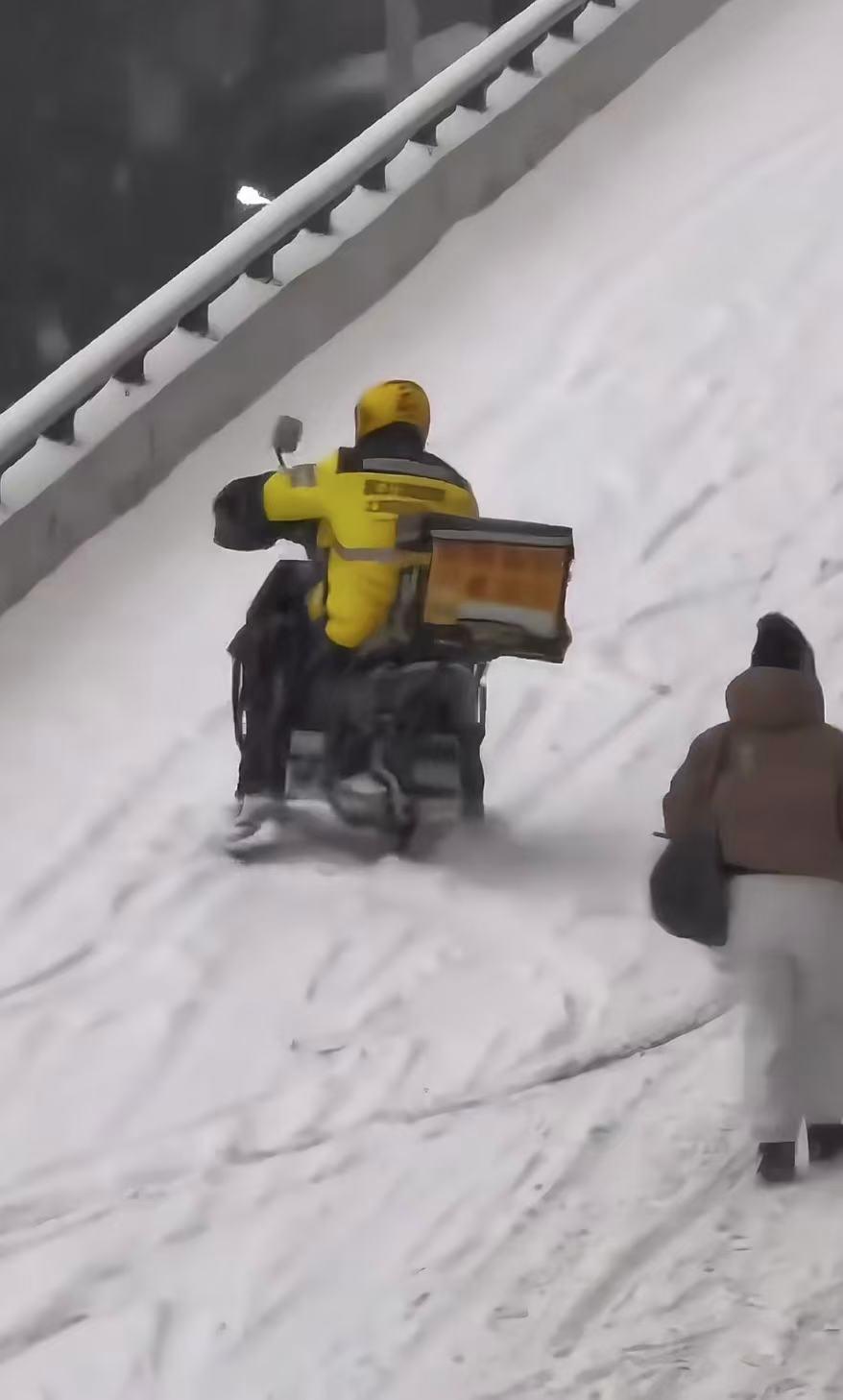 北方某地大雪
一位身着黄色外卖服的骑手
在雪地里骑着电动车东倒西歪
险象环生，却