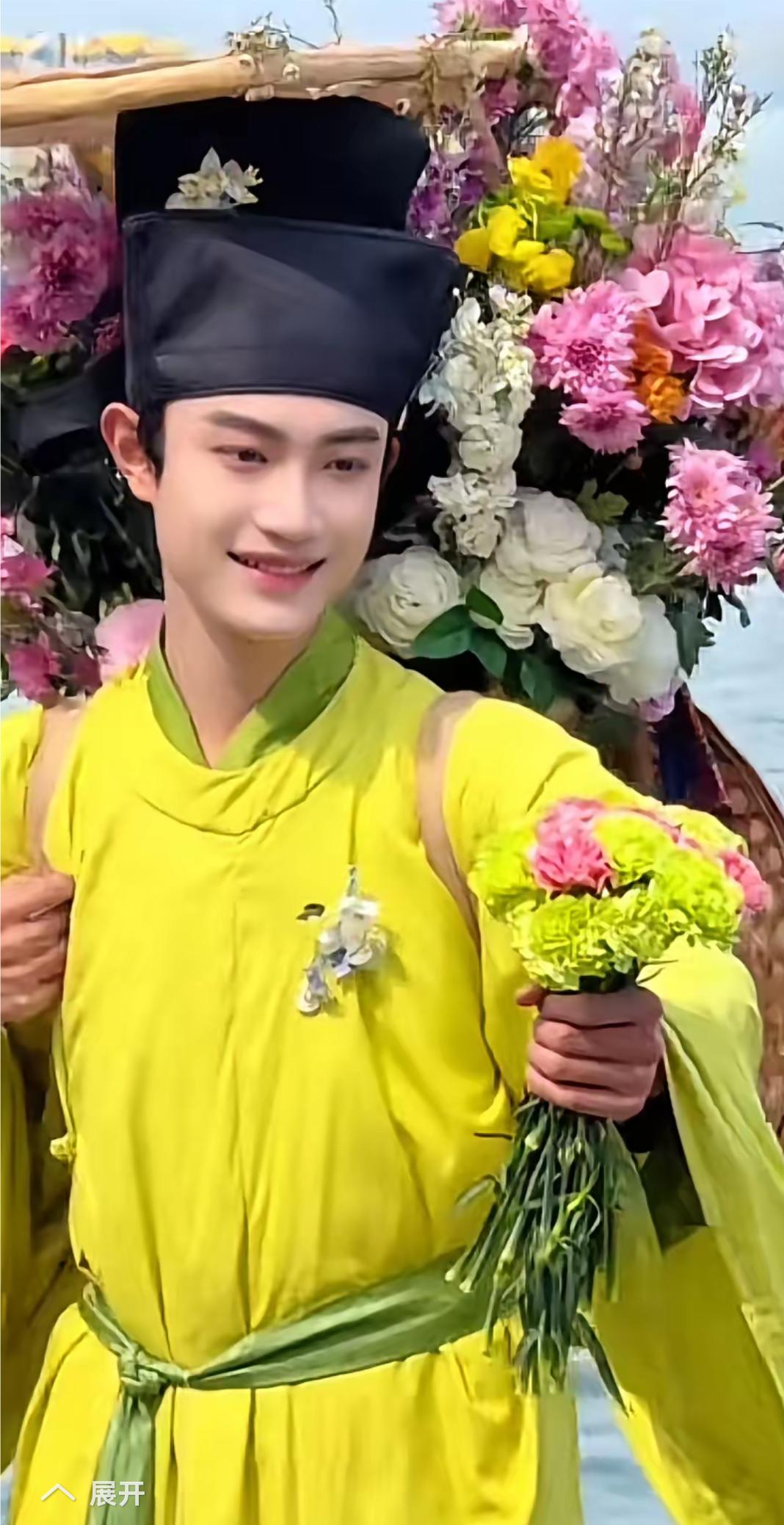 西湖卖花郎都这么帅，穿着嫩绿色汉服，后面背着古代书包，装着五颜六色花，手里拿着花
