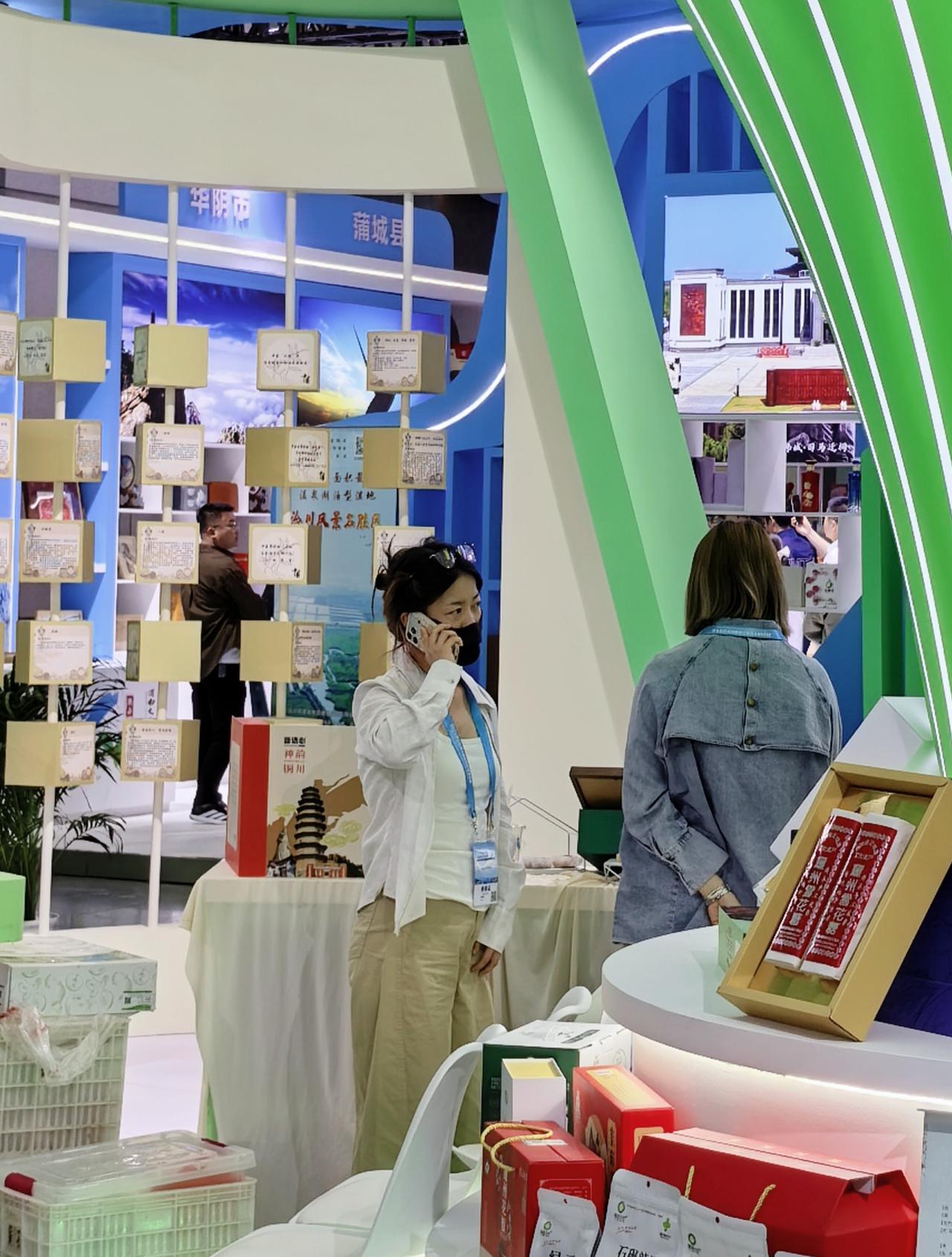 在展台上，发现蒲城的“千年贡梨”。石子馍也会拉丝，梨膏能扫码溯源。一位小姐姐在打