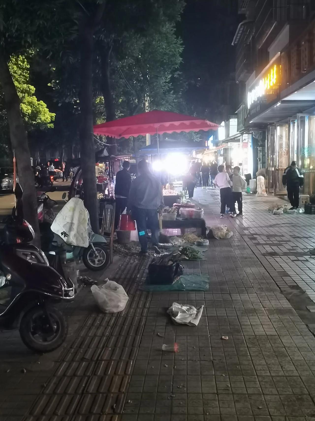 节日的晚上出去逛街，小巷里卖菜的小贩还不少。看到一位大姐正准收摊，她卖的丝瓜看上