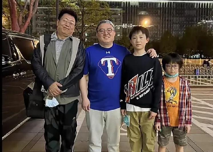 王为念与儿子王奥以及两个孙子即王奥的两个儿子一家三代在街头的一张留影。王为念是观