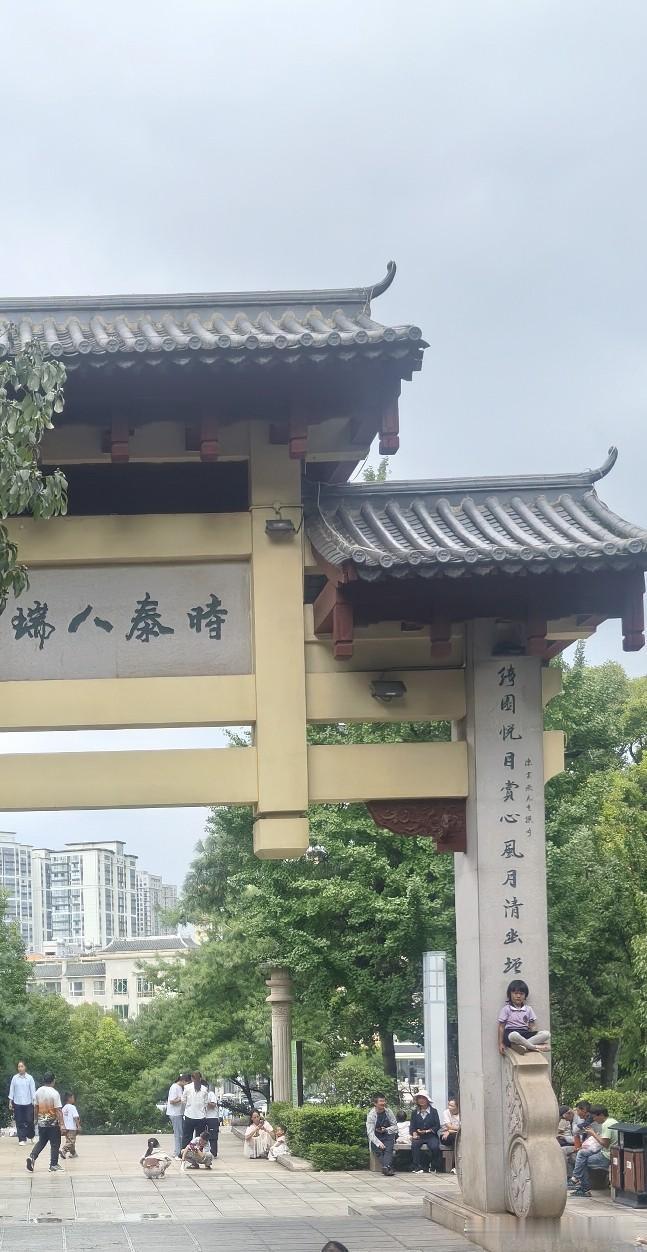 坐在石牌墙柱子上的小女孩。

前天我们去曲靖南城门的城墙上玩，看见一个四岁左右的