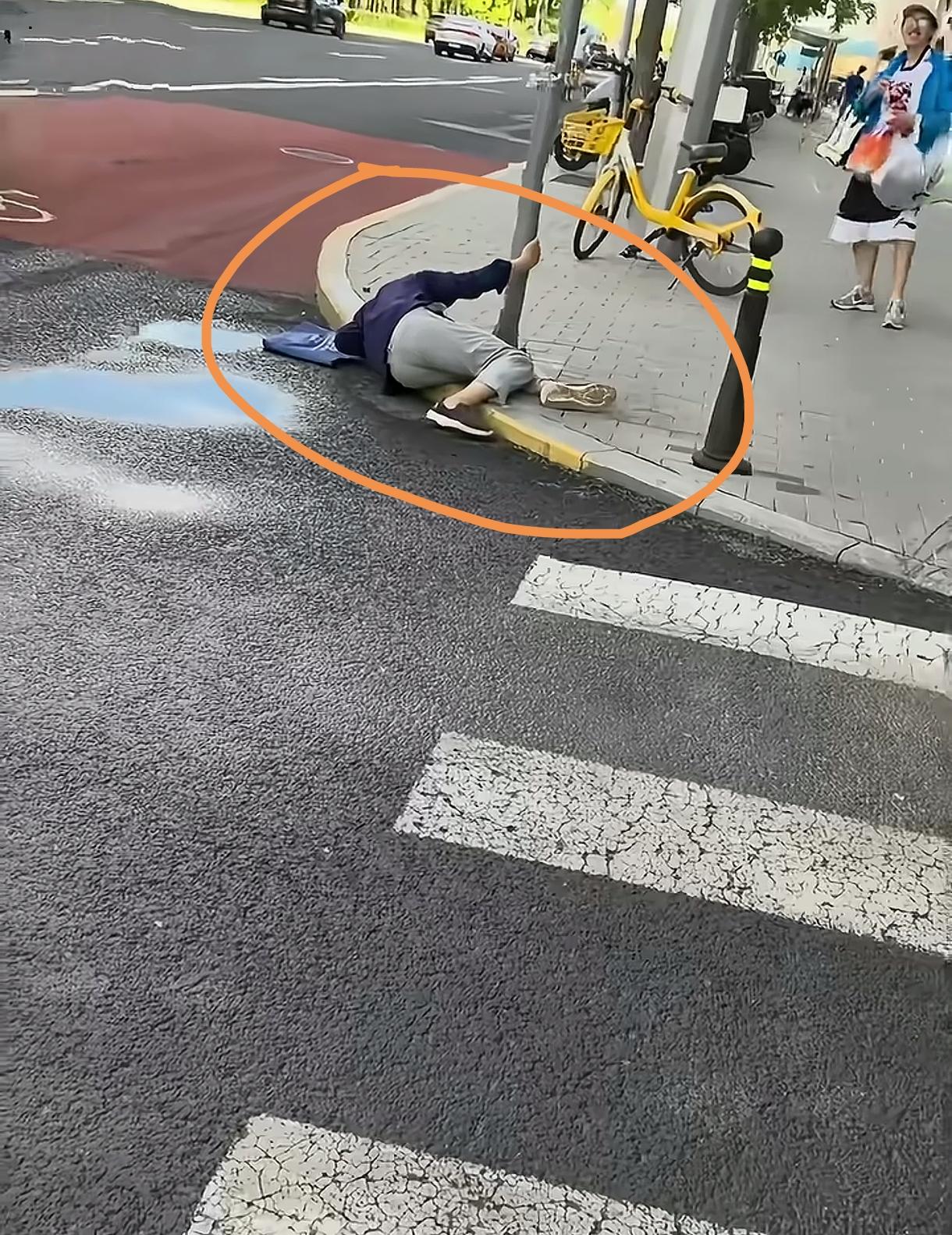 这是很扎心的视频，一个老人摔倒在路边，行人路过，没有一个人敢去扶起来。录视频的阿