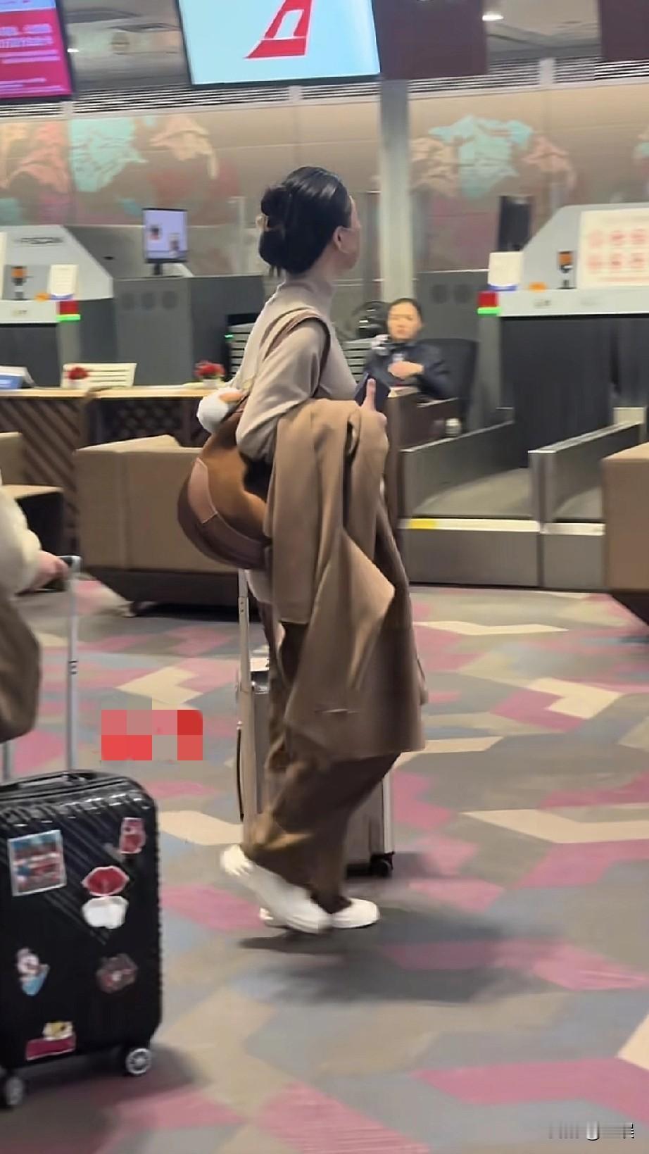 蒋欣机场浅棕色高领针织衫，搭配同色系下装，整体风格简约大气