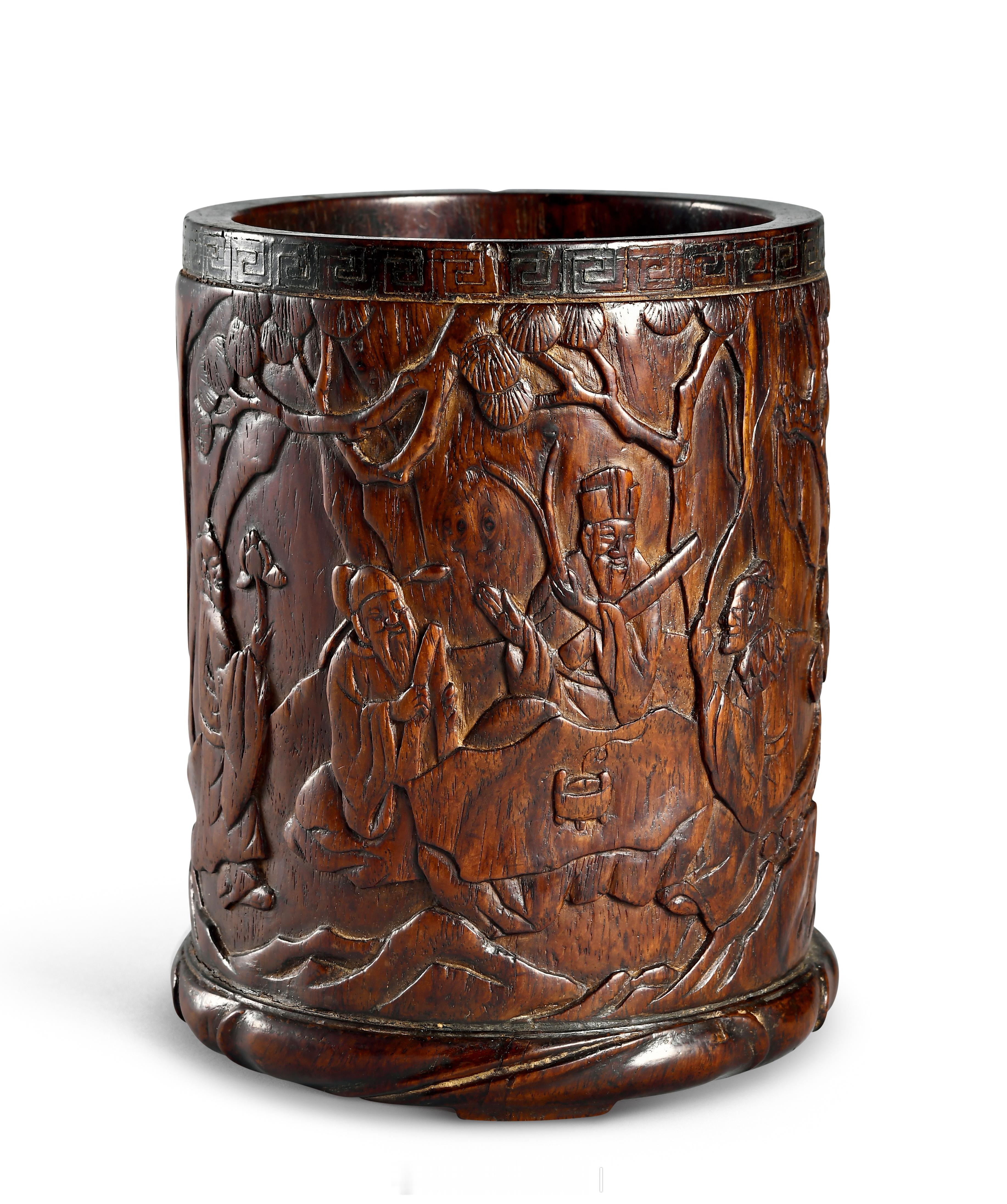 明末清初 紫檀松下高士图笔筒笔筒以紫檀为材，呈直筒型，平口直身，口沿处阴刻回纹一