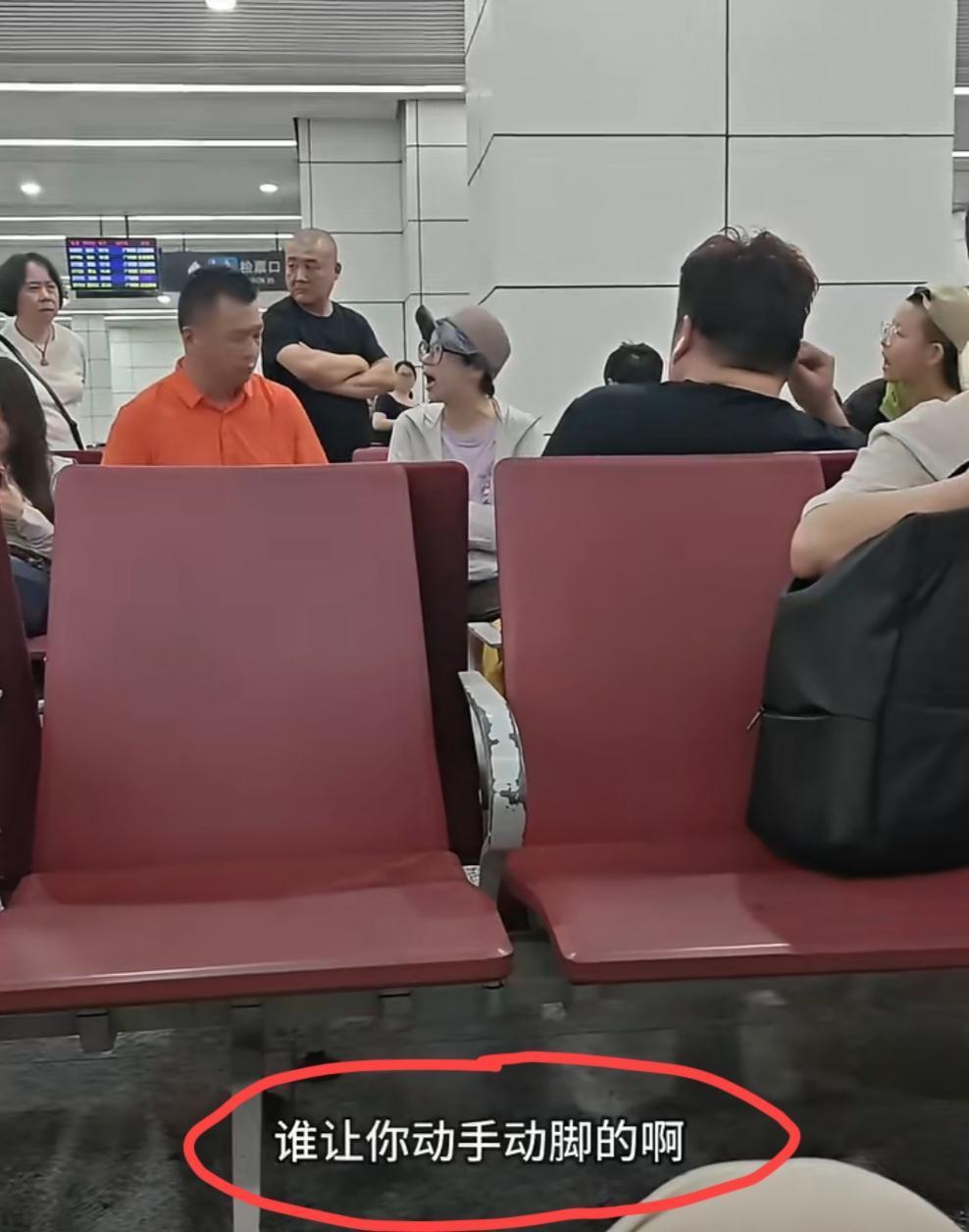 候客大厅里面的一幕，疑似这位橘色衣服的男子坐在了这对母子的行李上面，双方发生激烈