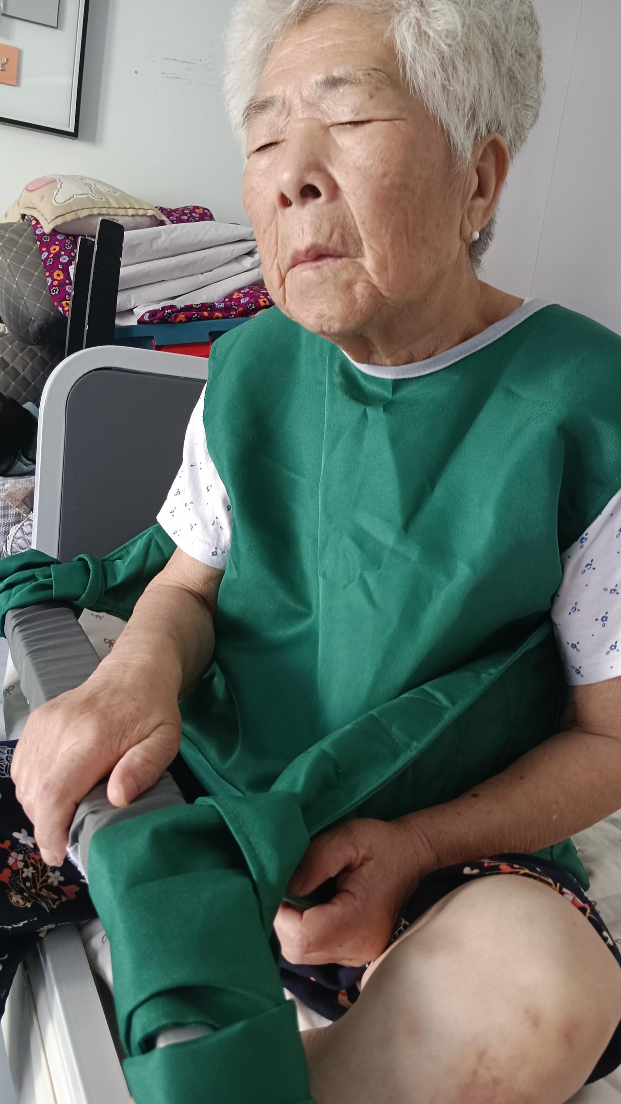 女儿给老母亲备好防护宿服。
老人年纪大，半夜意识不清总想起身，摔倒一次后果不堪设
