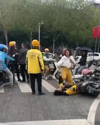 她用一只脚狠狠地踩在外卖小哥的头部。这个女人疯了吗？

10月8日，重庆大学城一