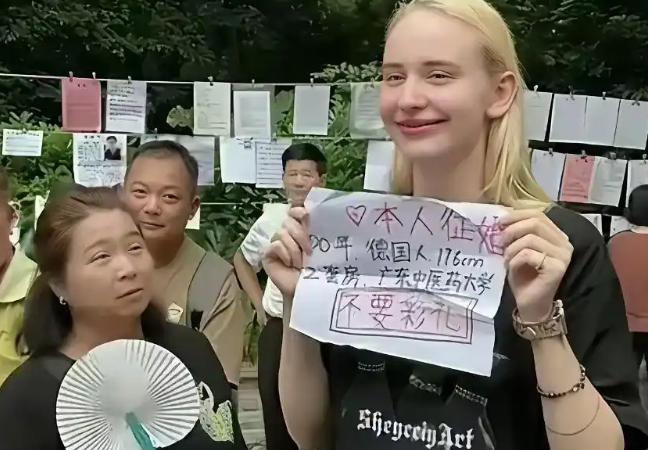 一个26岁的德国姑娘站在广州天河公园相亲角，身高176，在广州中医药大学工作，名