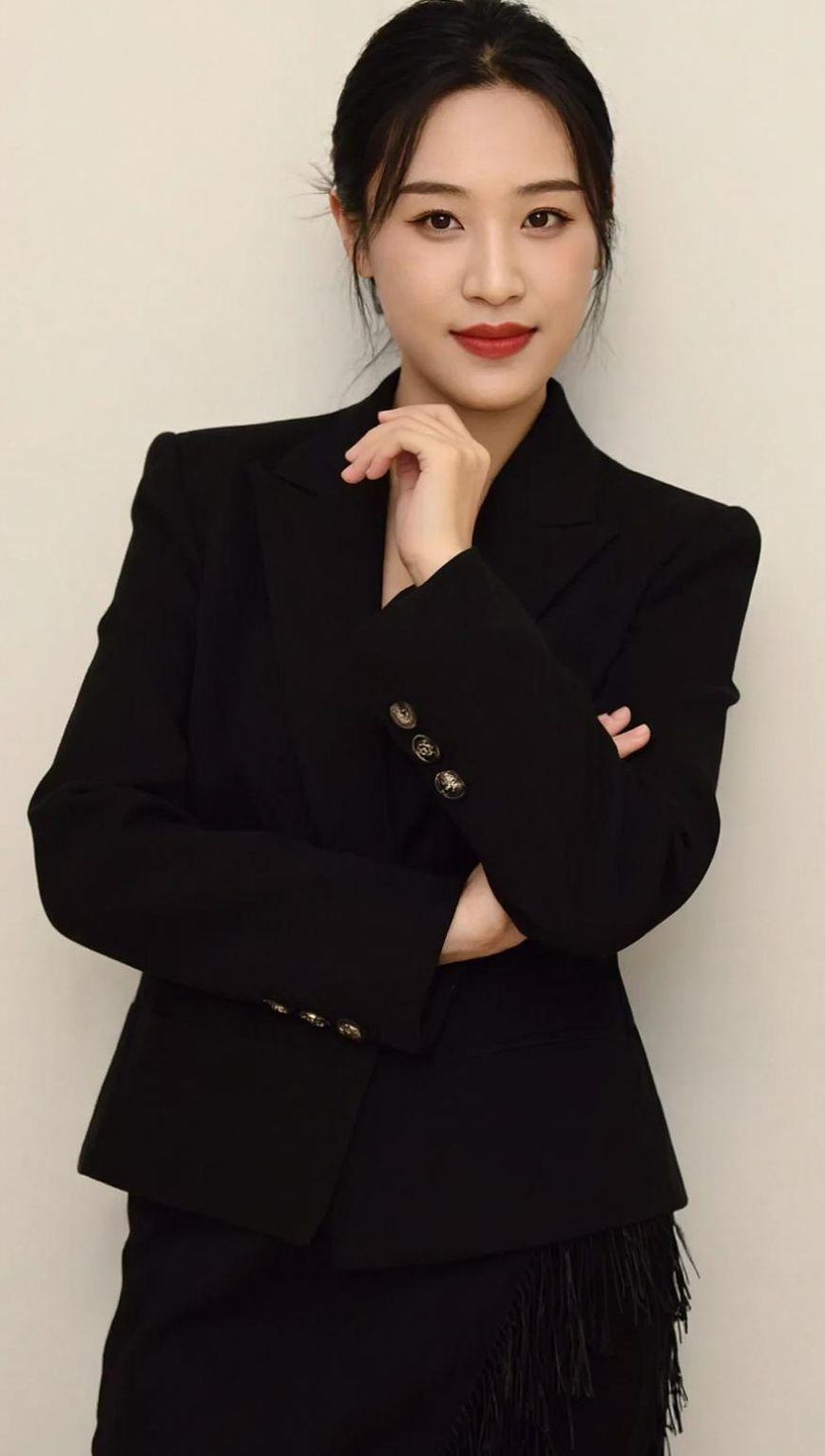 黑色西装勾勒出利落的线条，仿佛是都市夜空中划过的一道闪电。镜头前的自信姿态，像极