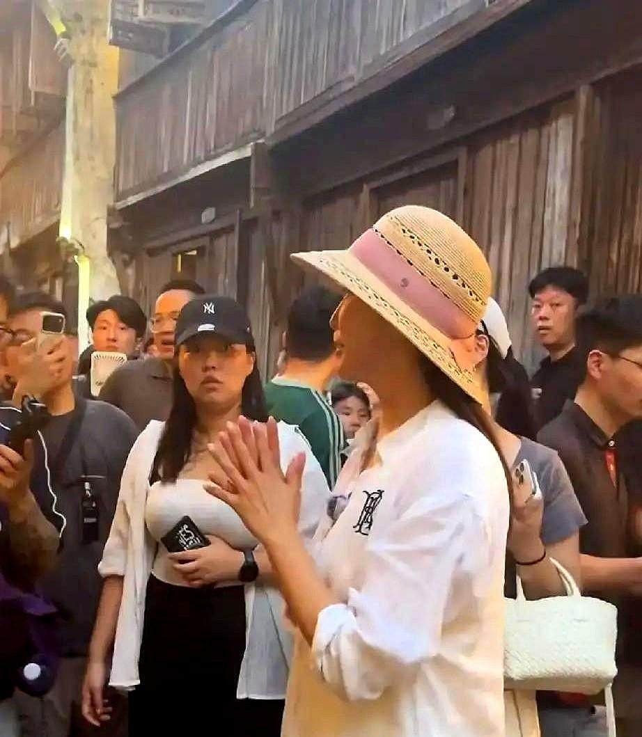 49岁的女星顶着素颜，挤在乌镇早茶摊人堆里，大口啃着白胖肉包子。

戴顶草帽套件