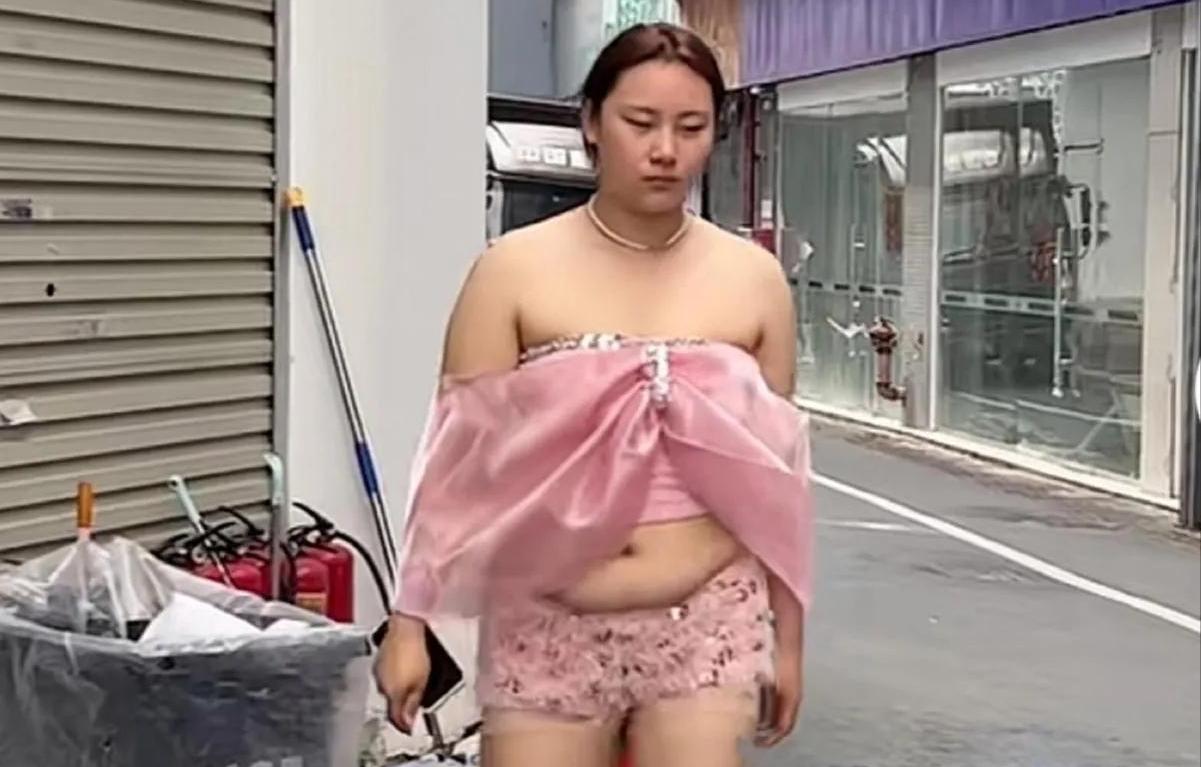 是什么给了她这样的勇气？
街边垃圾桶旁，粉色蝴蝶结上衣搭配碎花短裤，微胖身材踩着