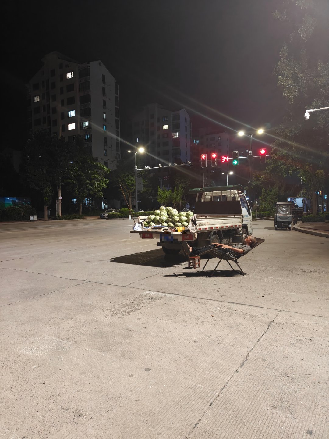 晚上10点多卖西瓜的老农在躺椅上睡觉乘凉的路人没有几个 