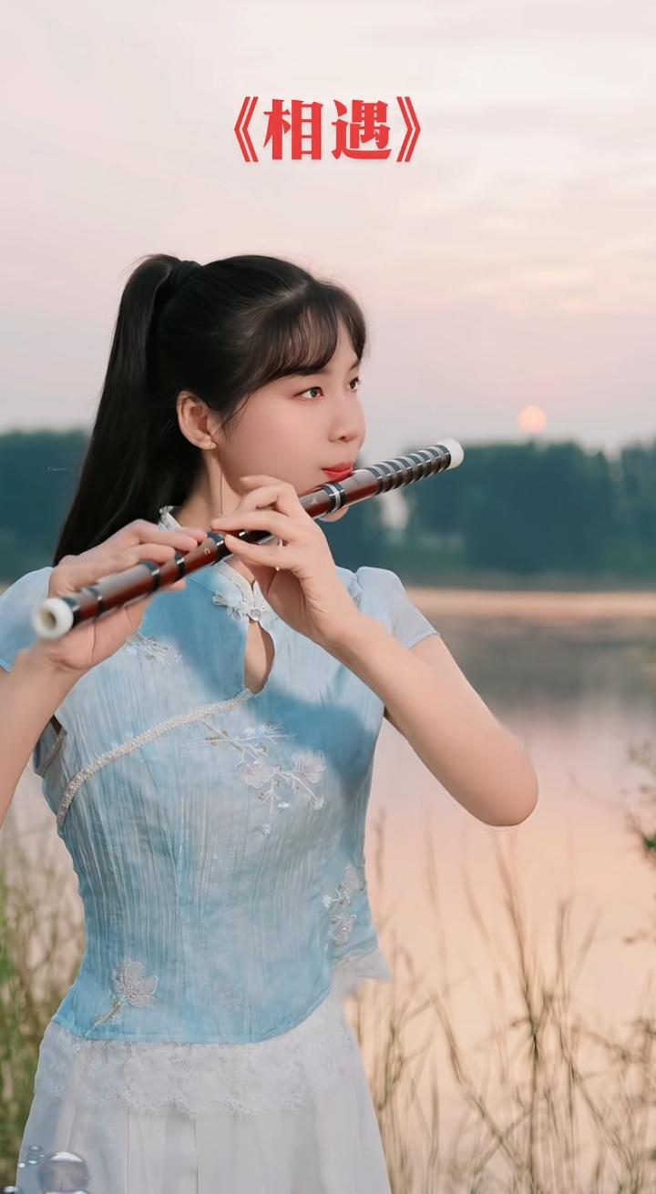 一个女孩在湖边吹着笛子。觉得女人最重要的是美貌还是人品 竹笛唱歌 竹笛姿势 练笛