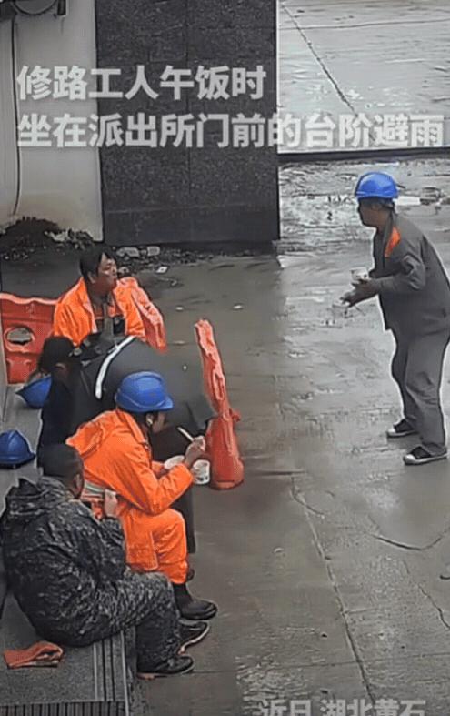 这民警火到人民日报了！湖北一群修路工人午饭时，为了避雨，来到派出所门前台阶坐下，