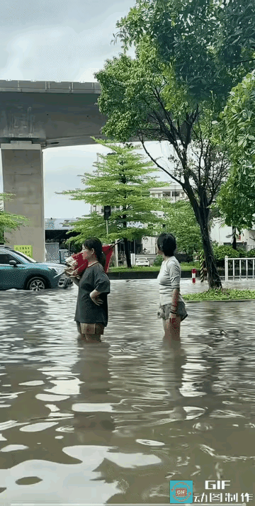 暴雨之后，这两个女孩下班的路上，看到有这么深的水，十分的开心，两个人站在齐大腿深