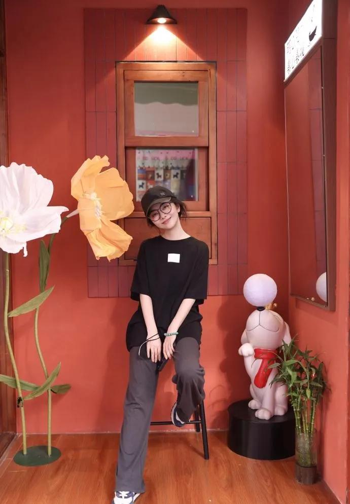 谭松韵这组私服随拍，走的就是随性日常路线。
宽松黑色短袖搭配灰色微喇长裤，棒球帽