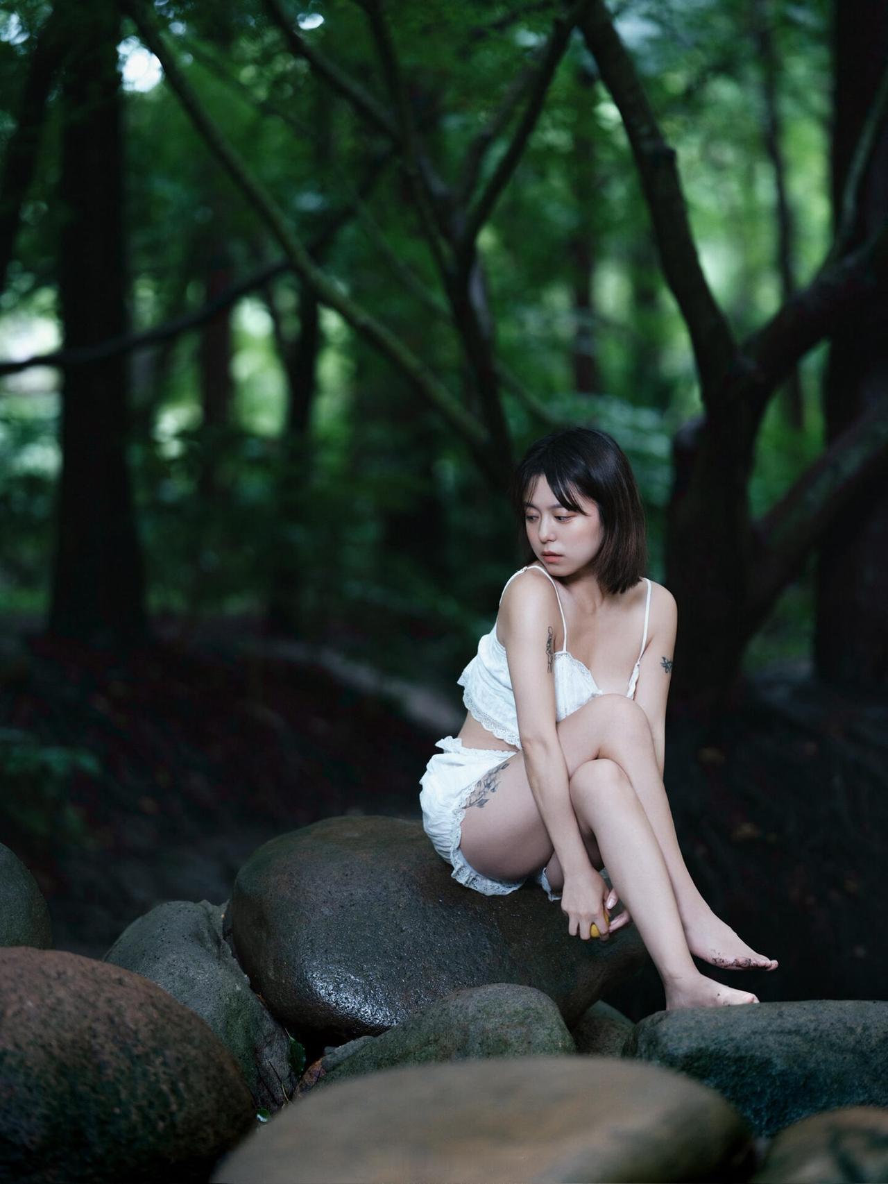 照片把焦点拉得很近，女孩手持柠檬，眼神清亮地看向镜头。白色蕾丝的细节在近景里清晰