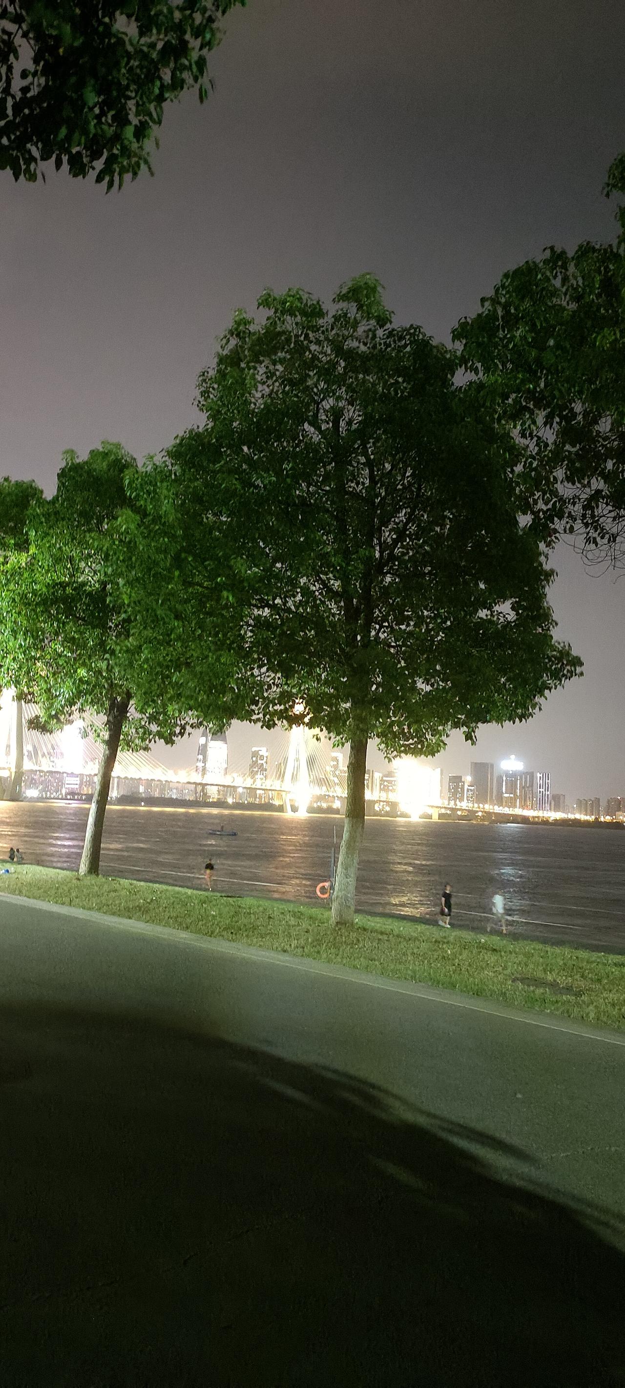 38度的高温天，到了晚上，暑气已经消散了一些。

我坐在江边的长椅上，看着涛涛奔