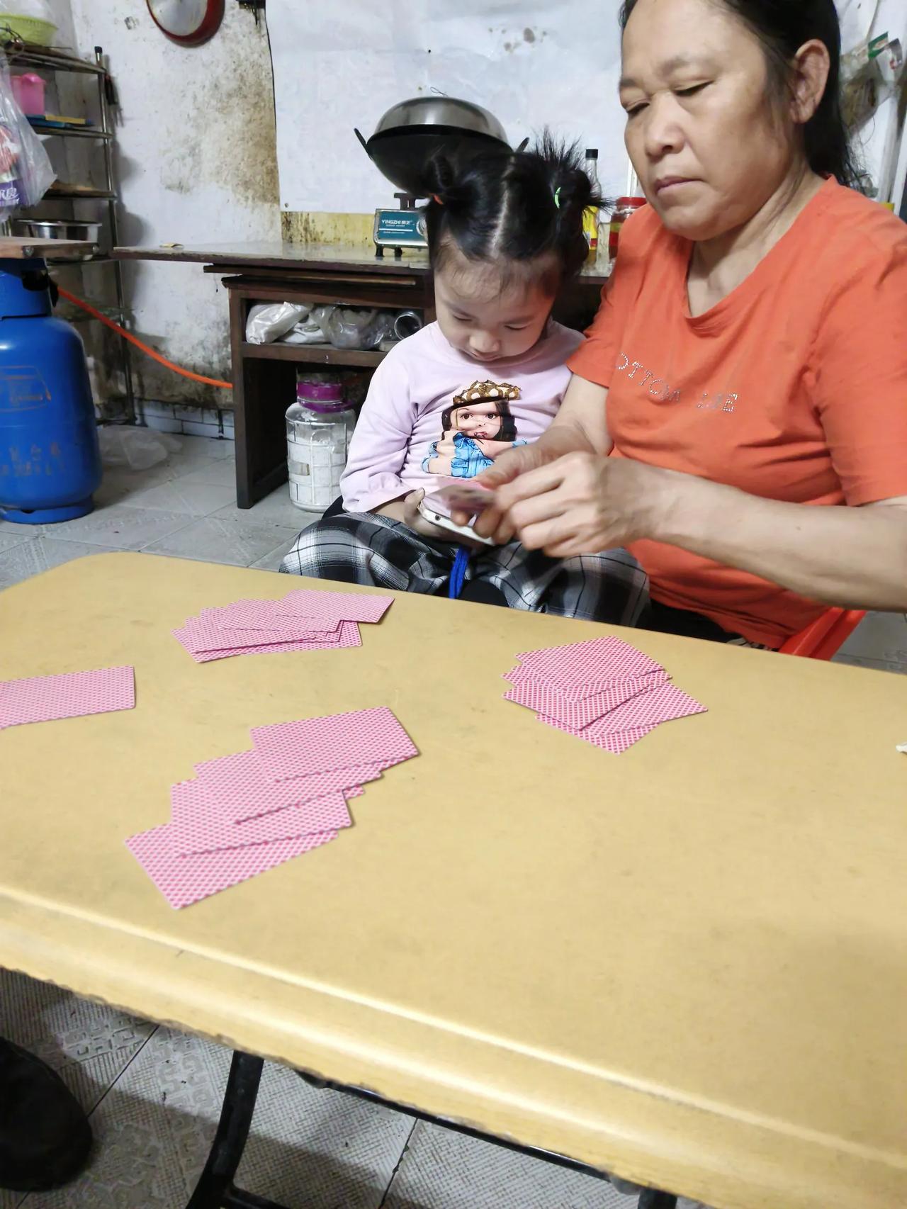 我姐打牌，孙女坐在她腿上，姐说我腿都麻了，你下去看吧，小姑娘不为所动，继续看她的