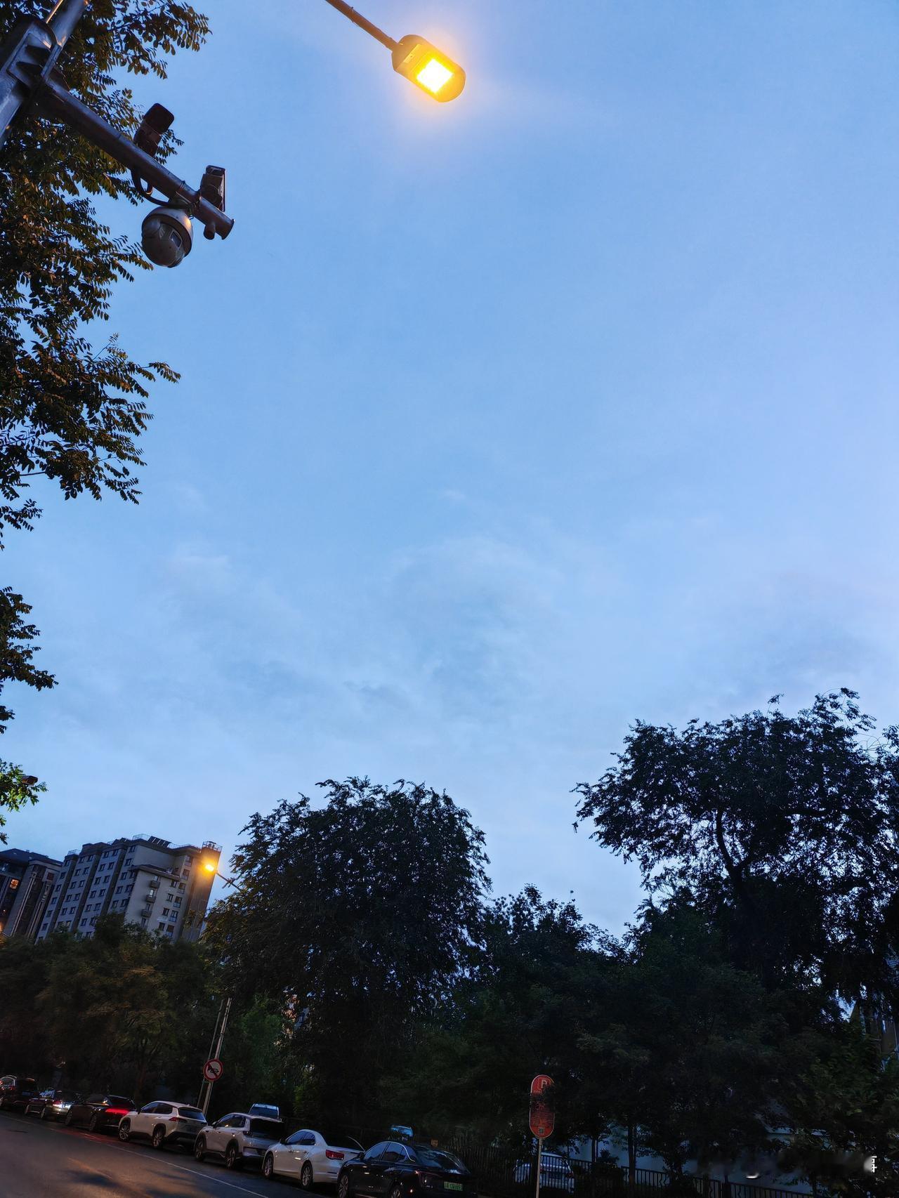 黄昏之际，街灯刚刚亮起，静谧的街道与远方的建筑相得益彰。
这是小雨过后的北京
傍
